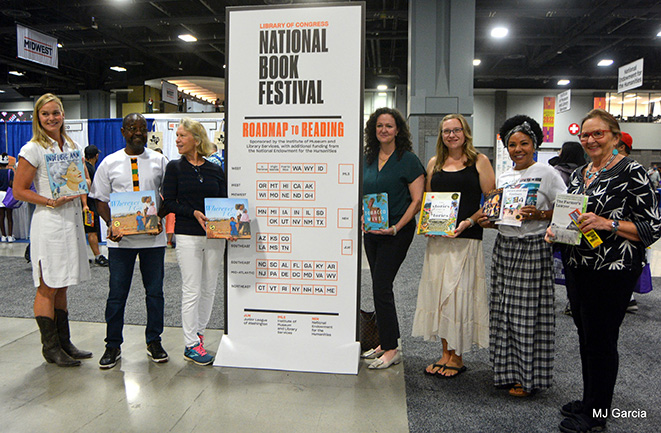 Authors posing with event sign