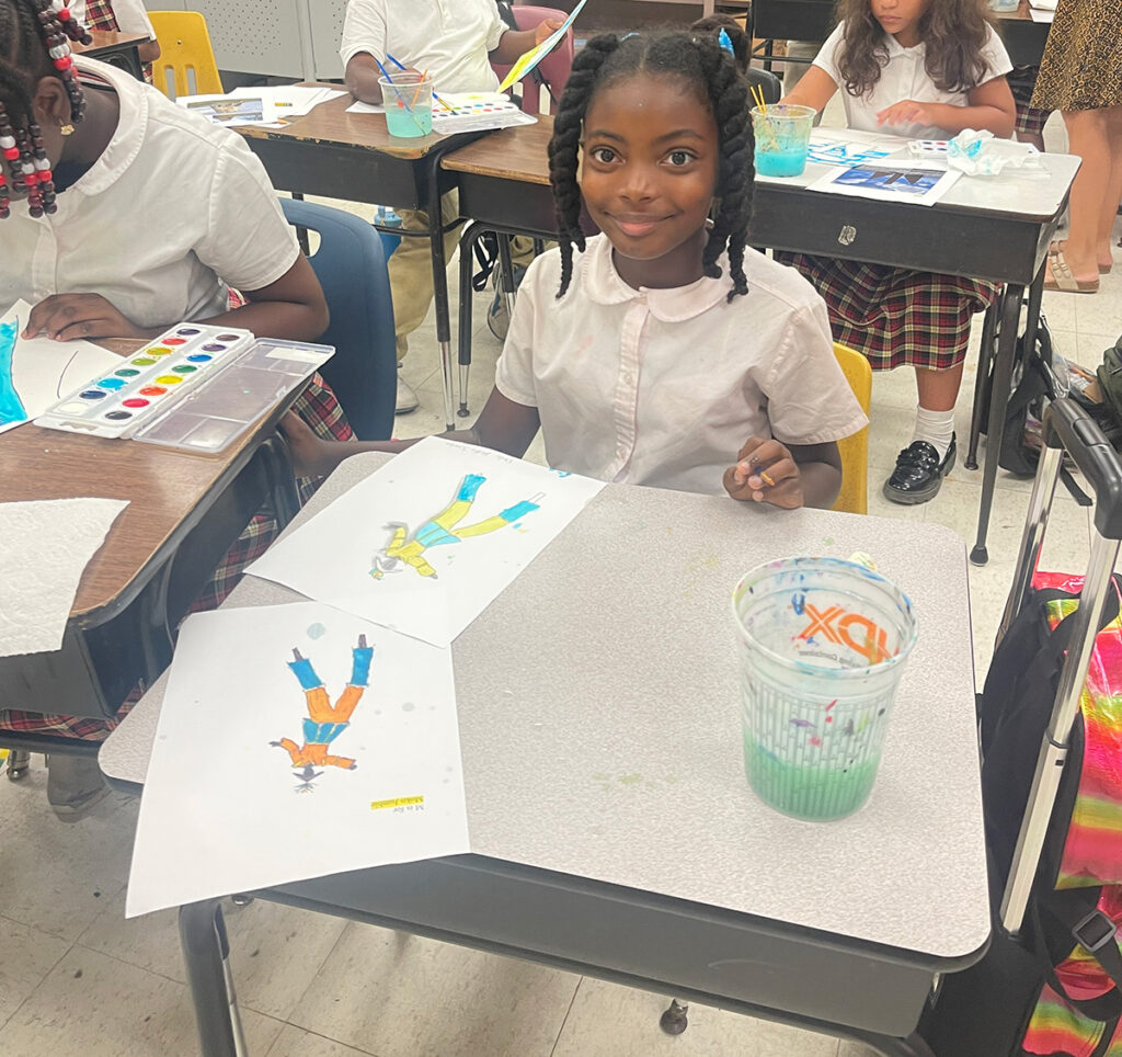 Children at their desks during painting time.